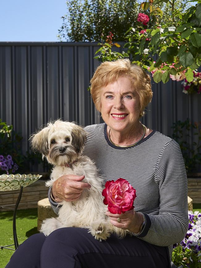 Sandy Mojsish with her roses and her puppy, Lulu at home in Royal Park, after winning best rose. Picture: Matt Loxton