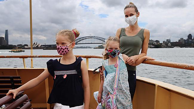 Liz Alagich and her daughters Mira, left, and Kaia ride the Manly ferry to Sydney’s CBD on Sunday after restrictions in their area were lifted. Picture: Jane Dempster