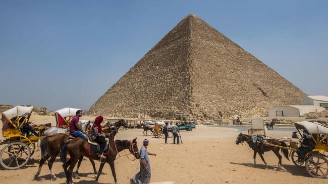Egyptians riding their carts past the Great Pyramid of Giza, also known as the Pyramid of Cheops or the Pyramid of Khufu, on the Giza Plateau, on the southern outskirts of the capital Cairo. Picture: AFP