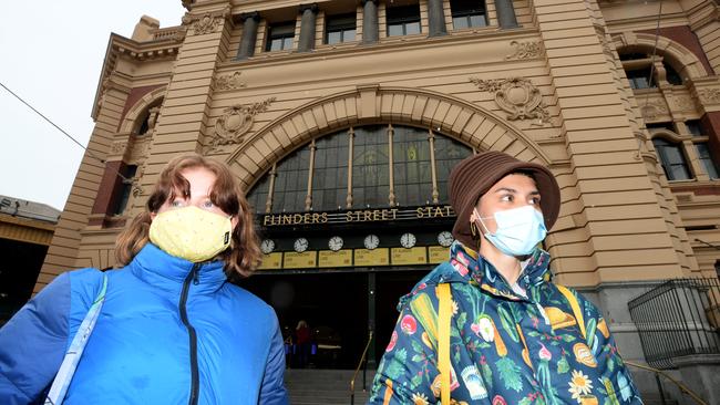 People wearing masks outside Melbourne’s Flinders Street Station. The city is almost empty as stage-3 restrictions force people to stay at home. Picture: Andrew Henshaw/NCA NewsWire