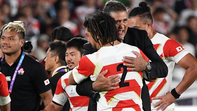 Japan coach Jamie Joseph gives his players a hug after their incredible win.