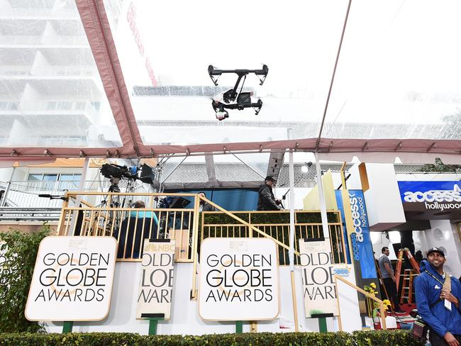 Workers prepare for the possibility of rain before the 72nd annual Golden Globe Awards.