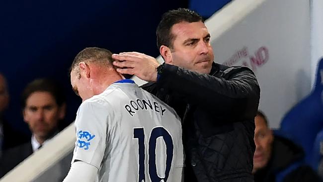 Everton's interim manager David Unsworth (R) substitutes Everton's English striker Wayne Rooney.