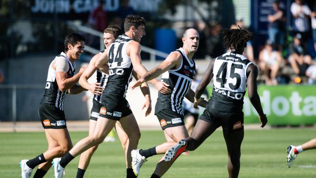 Teammates celebrate after Matthew Broadbent, middle, scores a goal during the SANFL match against North Adelaide at Alberton Oval on Sunday. Picture: AAP Image/ Morgan Sette