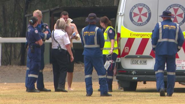 A man is treated by paramedics as a Careflight crew arrives on scene to transport firefighters suffering serious burns in the Bargo bushfires to hospital. Picture TNV