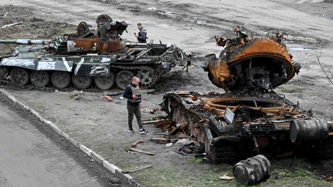 Residents look at destroyed Russian tanks on the outskirts of Buzova village, west of Kyiv. Picture: AFP.