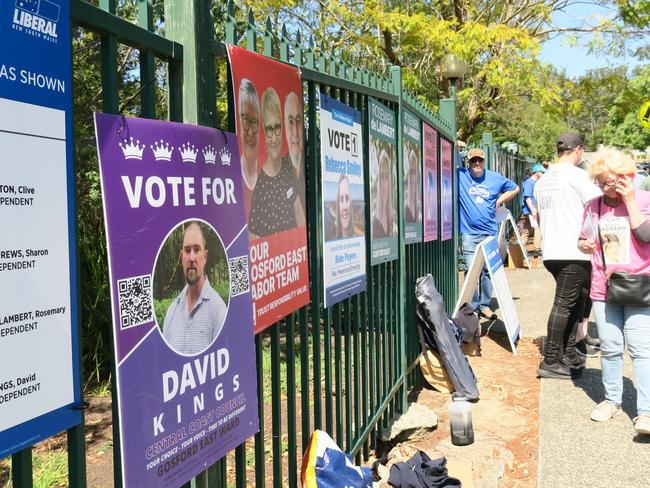 Liberal helper Guy McKanna at the end of a row of posters at the Erina High School polling booth. Central Coast Council Election 2024. Picture: NewsLocal