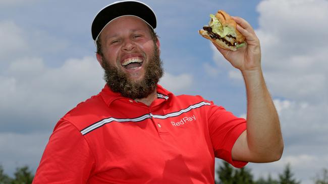 Andrew Johnston poses for a portrait with a hamburger.
