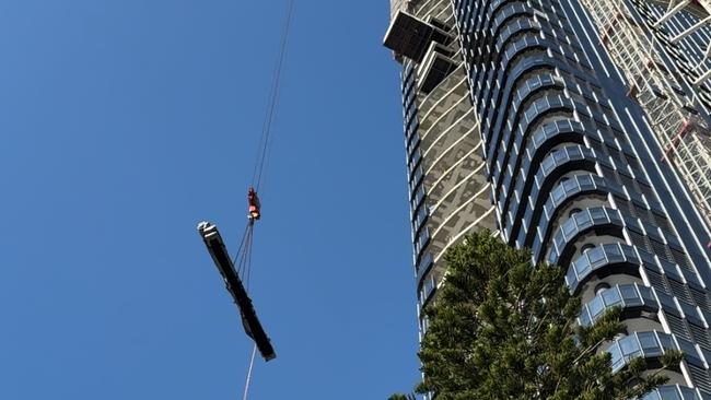 A tower crane lowers materials from the Midwater development at Main Beach on Monday, September 2. Photo: Kathleen Skene