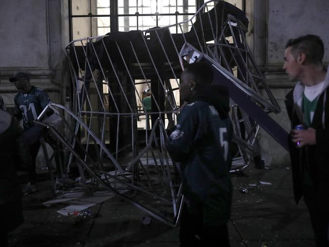 Fans pass a destroyed hotel canopy.