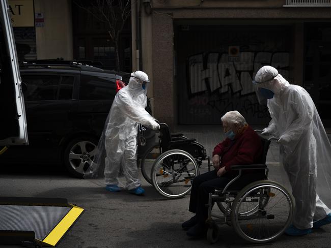 A volunteer of the Spanish NGO Open Arms pushes in a wheelchair an elderly resident of a nursing home with coronavirus symptoms to a Barcelona hospital. Picture: AP