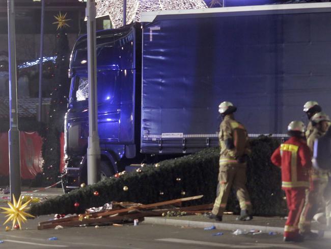 Firefighters stand beside a truck which ran into a crowded Christmas market and killed several people in Berlin. Picture: AP