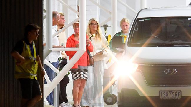 Shane Warne's family, from left, father Kieth Warne, son Jackson Warne, mother Bridgette Warne, daughter Brooke Warne and ex-wife Simone Callahan look on as a white van bearing his body exits a hangar at Essendon Airport. Picture: AAP