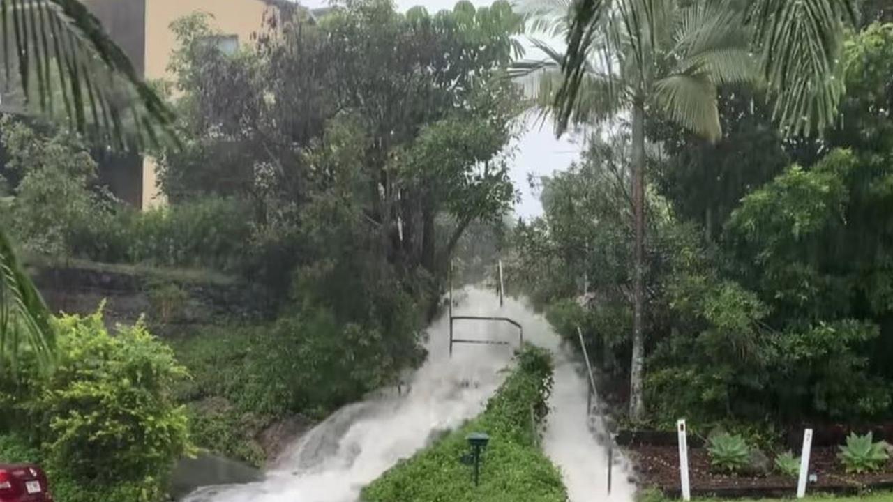 Water pours down a driveway on Kerenjon Ave at North Buderim after the heavy rain and flooding on the Sunshine Coast.