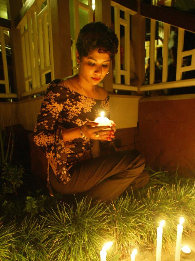 Singh Memorial at New Farm Park: Sonia Pathik holds a candle of remembrance for her slain siblings. Picture: Vanessa Hunter