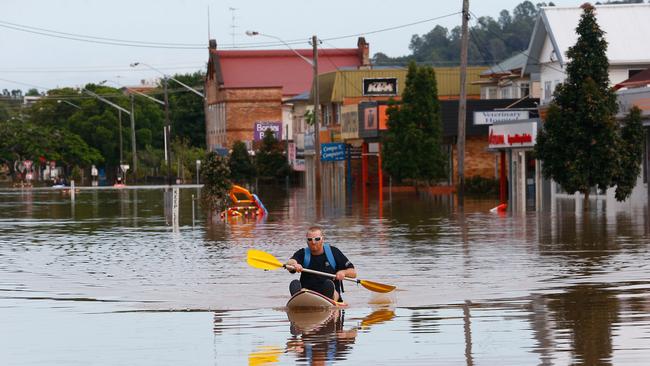 A man paddles a kayak down a street in Lismore, Australia. Picture: Getty