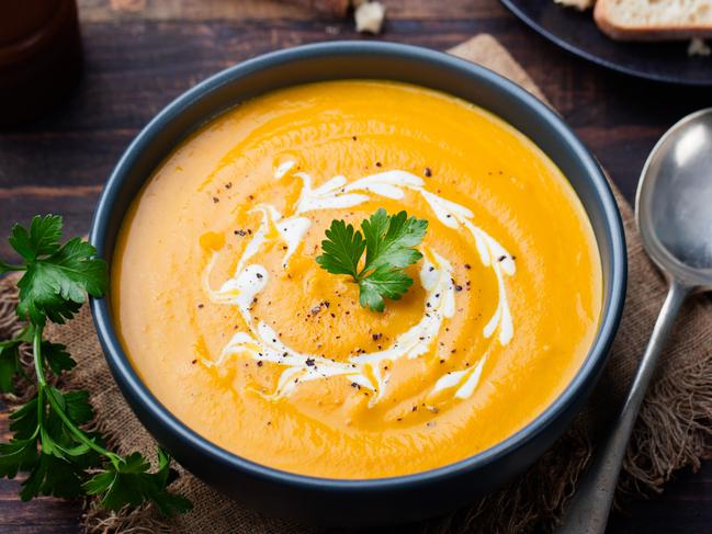 Pumpkin soup with cream and parsley on dark wooden background Picture: Istock