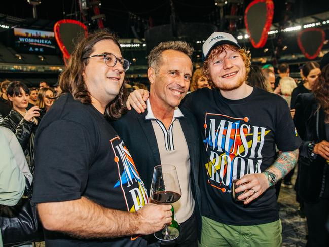 04/03/2023: After Ed Sheeran's record-breaking performance to 109,500 people at the Melbourne Cricket Ground, Mushroom Group CEO Matt Gudinski (left), singer-songwriter Mark Seymour (centre) and Sheeran (right) shared a drink together on the MCG turf. Picture: Brian Purnell / Mushroom Creative House