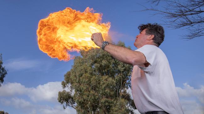 David “Juggs” Russell blowing a fireball from his mouth at his property in Aldinga Beach. Picture: Ben Clark