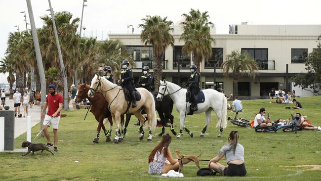 Melbourne police check social-distancing rules at the St Kilda foreshore on Sunday, above; while the crowds flocked to Bondi Beach in Sydney, below. Picture: NCA NewsWire / Daniel Pockett