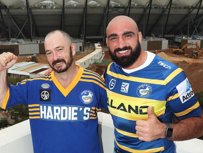 Parramatta fan Dave McDonald who is Parramatta's 20,000th member, with Parramatta NRL player Tim Mannah. Dave will get a VIP package to the first home game at BankWest Stadium. Dave and Tim with the new stadium in the background from Parramatta Leagues Club, Sydney. Picture: Brett Costello