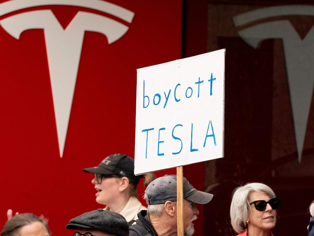 Demonstrators protest against Elon Musk and Tesla in the US... Australian owners are starting to make their own moves. Picture: AFP