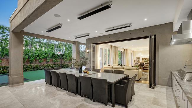 A covered alfresco deck overlooks the yard.