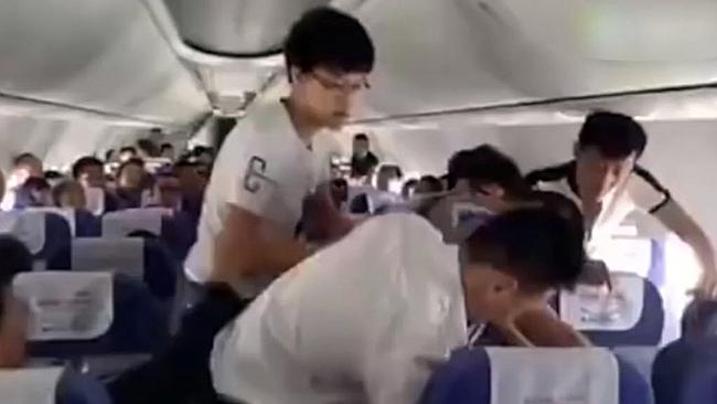 Passengers restrain a man who tried to enter the cockpit for a flying lesson. Picture: CEN/AUSTRALSCOPE.