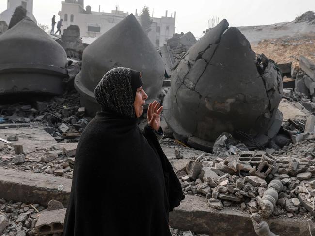 A woman walks near the Al-Faruq mosque, levelled by Israeli bombardment in Rafah in the southern Gaza Strip on February 25, 2024, amid continuing battles between Israel and the Palestinian militant group Hamas. (Photo by MOHAMMED ABED / AFP)