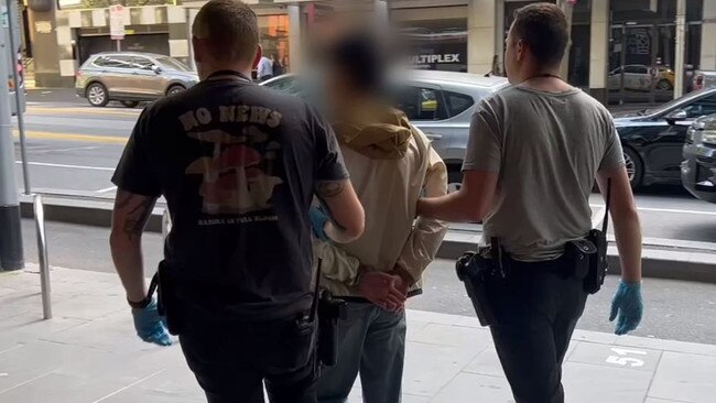 One of the 15 arrested people is taken into custody by police. Picture: VicPol