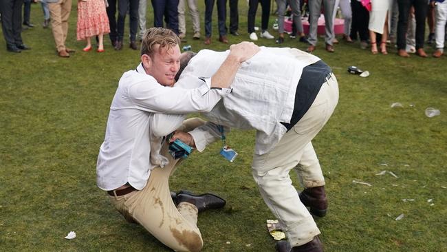 Racegoers wrestle on the lawn late in the day. Picture: Scott Barbour/AAP