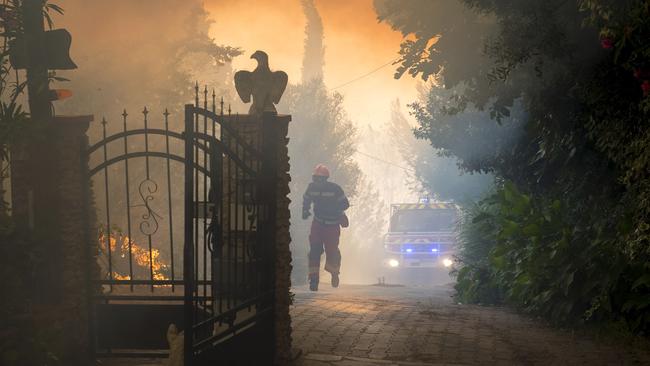 This photo provided by the Bataillon des Pompiers de Marseilles (BMPM) shows a firefighter running past a fire near Marseilles, southern France. Picture: AFP