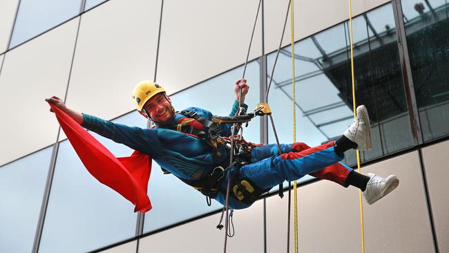 Window cleaner Aurelien Bret dresses up as Superman to cheer up patients while he works outside the children’s hospital. Photo: Claudia Baxter