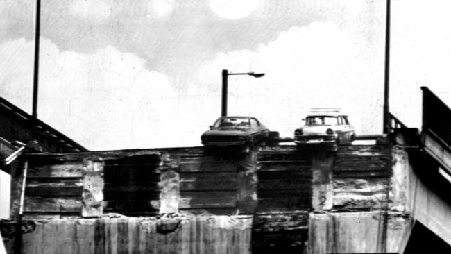 Holden Monaro (L) driven by Frank Manley &amp; FB wagon driven by Murray Ling, hang over edge of Tasman Bridge after section collapsed when hit by ship Lake Illawarra on Hobart's River Derwent.