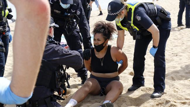 A woman is arrested at Elwood Beach. Picture: Matrix