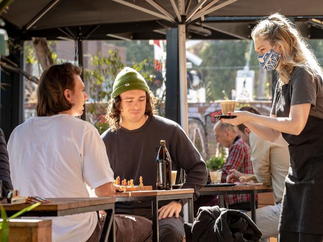 Customers of Lux Foundry cafe in Brunswick, Melbourne, are served by a barista wearing a face mask in 2020. Picture: Getty Images