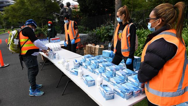 A man collects hand sanitiser from a station ahead of the rally. Picture: AAP Image/James Ross