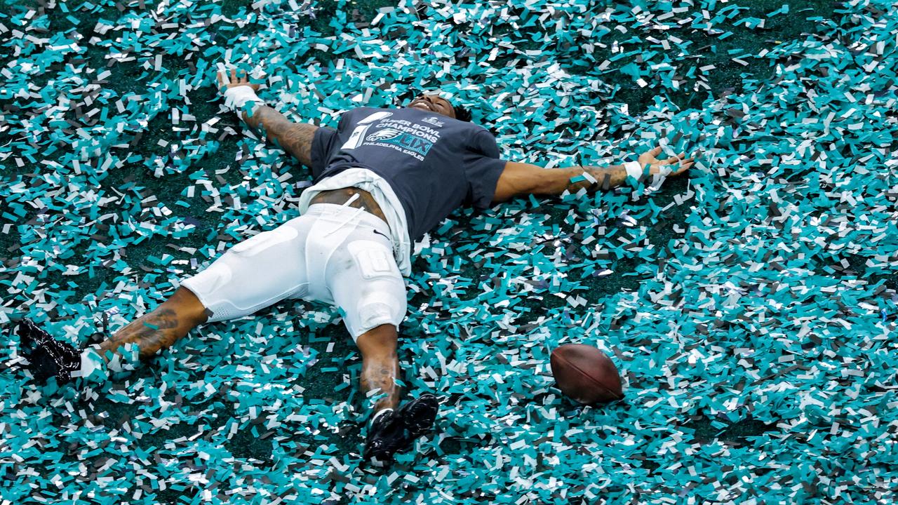 Eagles players soaked it up by making angels in the confetti. (Photo by Patrick Smith/Getty Images)