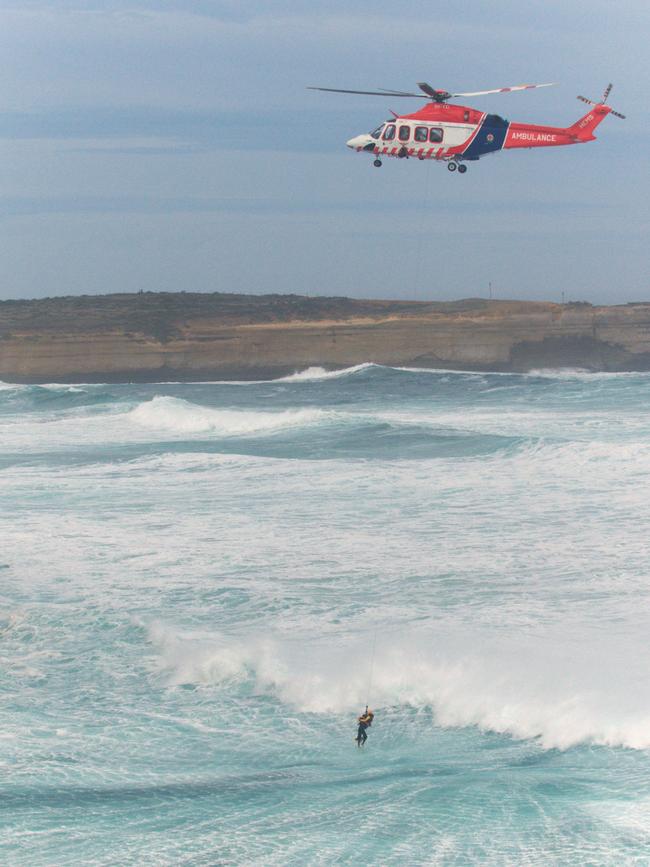 A helicopter saved a rescuer and the tourist from the surf. Picture: Ian McCauley