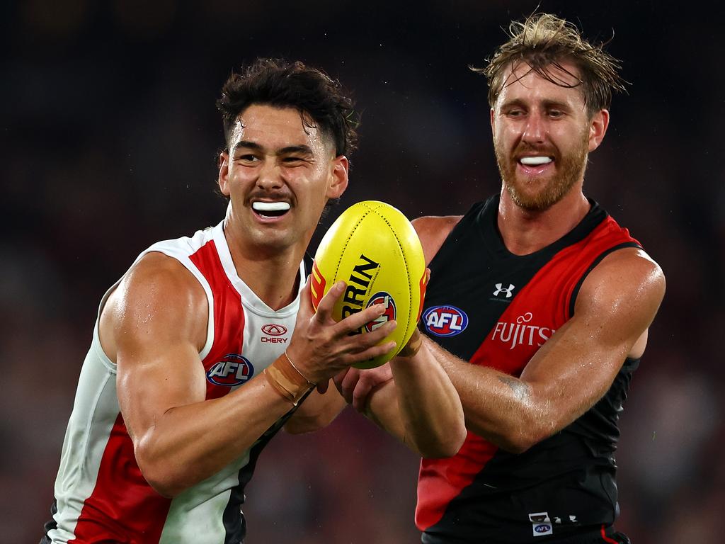 MELBOURNE, AUSTRALIA - MARCH 30: Mitch Owens of the Saints is tackled by Dyson Heppell of the Bombers  during the round three AFL match between Essendon Bombers and St Kilda Saints at Marvel Stadium, on March 30, 2024, in Melbourne, Australia. (Photo by Quinn Rooney/Getty Images)