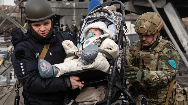 Servicemen carry a baby during the evacuation. Thousands of residents of Irpin have to abandon their homes and evacuate as Russian troops are bombing a peaceful city. Picture: Mykhaylo Palinchak/SOPA Images/LightRocket via Getty Images