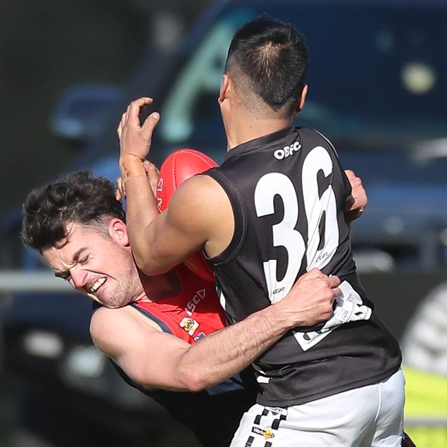 Omeo-Benambra’s Jerome Diomegracia is met solidly by Swifts Creek’s Beau Hack.