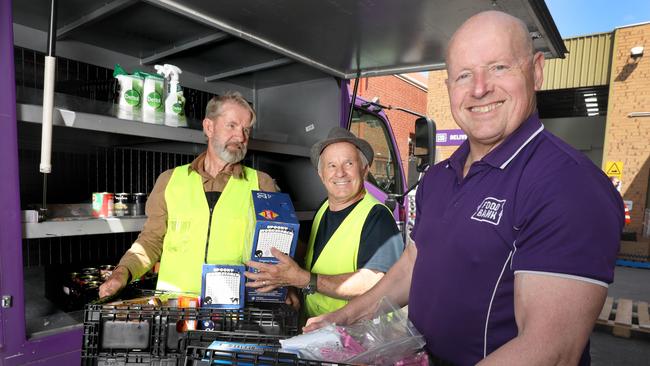 While the Voice debate ranges, more Australians than ever are going hungry because of rising cost of living. At Foodbank headquarters at Edwardstown, volunteers Chris Rankin (beard) and Alan Biss, with CEO Greg Pattinson (front) load a van with food for delivery this week. Picture: Dean Martin