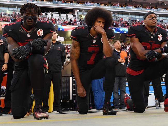 (FILES) In this file photo taken on October 6, 2016  (L-R) Eli Harold #58, Colin Kaepernick #7, and Eric Reid #35 of the San Francisco 49ers kneel in protest during the national anthem prior to their NFL game against the Arizona Cardinals at Levi's Stadium  in Santa Clara, California.   National Football League owners reached agreement May 23, 2018 on a policy which would require players to stand during the national anthem but give them the option of remaining in the locker room if they preferred.The issue of how to handle player protests has loomed over the NFL's owners meeting in Atlanta, with the sport anxious to avoid a repeat of the controversy which divided the league last season.The kneeling protest was started by former San Francisco 49ers quarterback Colin Kaepernick in 2016 as a way to protest police brutality, racial injustice and social inequality. Kaepernick's protest followed a wave of deaths involving black men during confrontations with law enforcement.   / AFP PHOTO / GETTY IMAGES NORTH AMERICA / Thearon W. Henderson