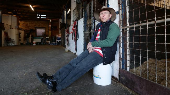 Former jockey Chris Munce takes some time out the stables. Picture: Peter Wallis