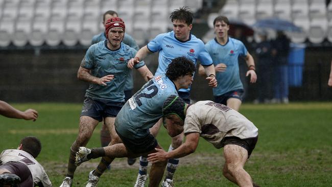 NSW's Leo Bassingthwaighte is tackled by Queensland's Jakeb Horne.