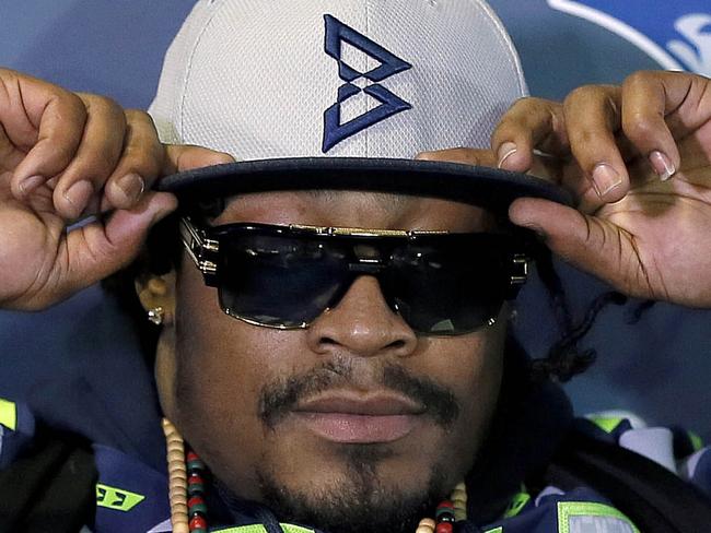 Seattle Seahawks' Marshawn Lynch adjusts his cap during an interview for the NFL Super Bowl XLIX football game, Thursday, Jan. 29, 2015, in Phoenix. The NFL may not like those 