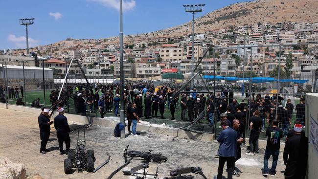 Residents gather on the soccer field in Majdal Shams on Sunday following the rocket attack that killed 12 children. Picture: Menahem Kahana / AFP