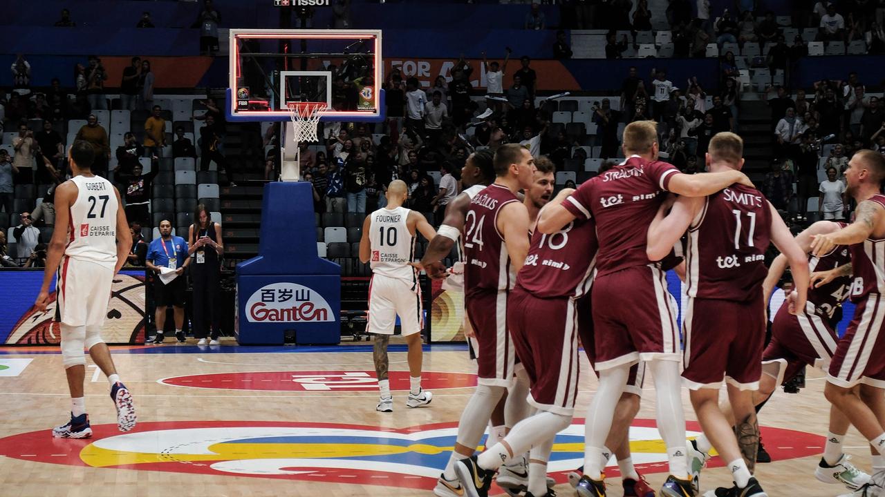 France's Rudy Gobert (L) and Evan Fournier (2nd L) react as Latvia's players celebrate.
