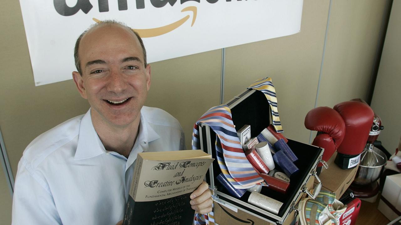 Bezos moved to Seattle with MacKenzie to start the online venture in the mid-1990s. Here he holds a copy of the first book he sold on the site. Picture: AP / Ted S. Warren